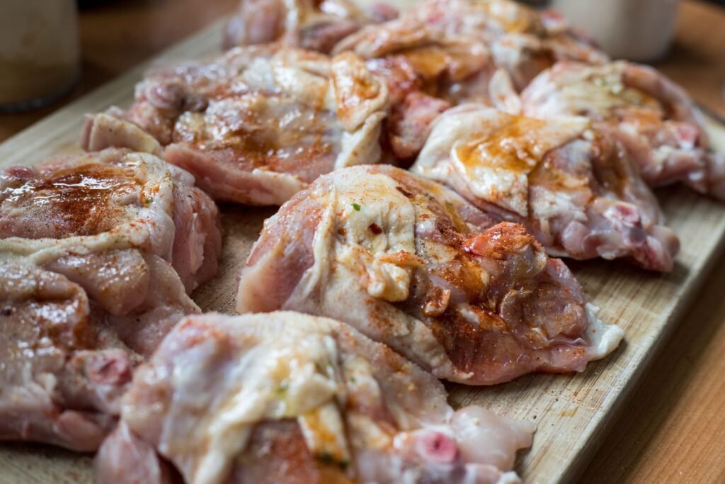 Raw chicken cuts on a wooden board