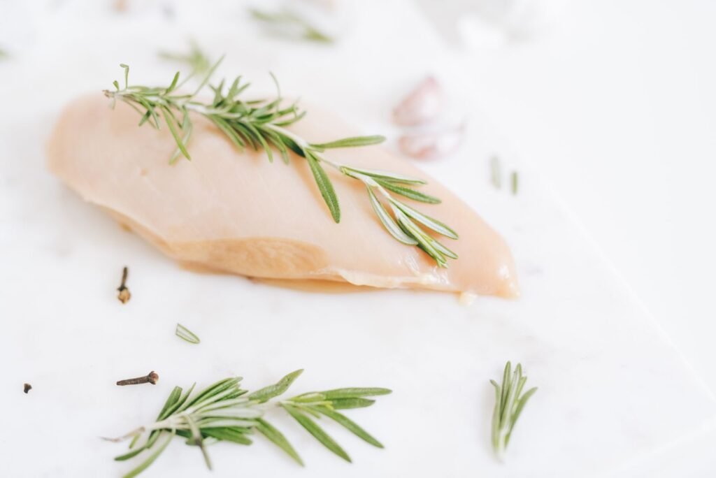 Raw chicken breast on a white surface