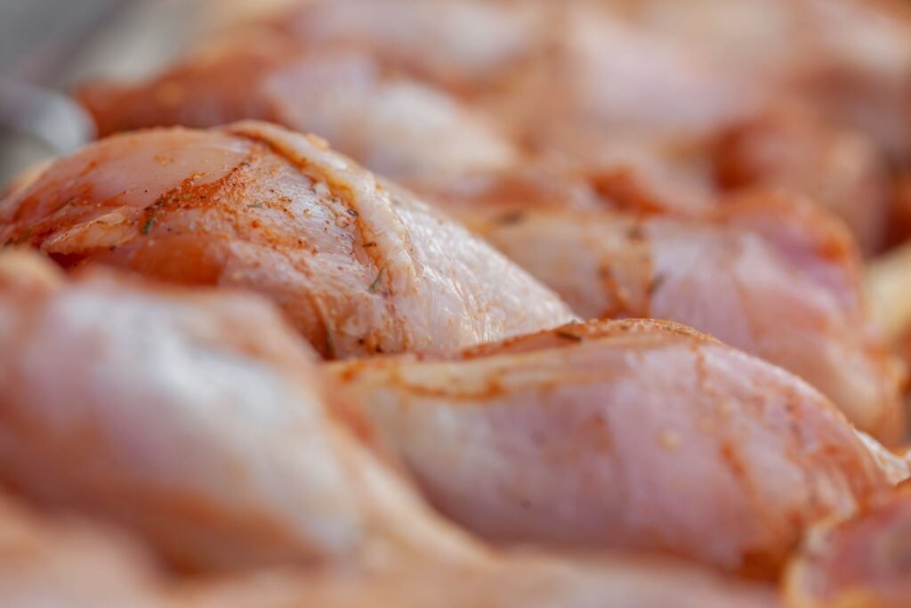 Raw chicken drumsticks in a row